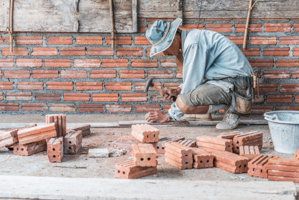 mason repairing a brick wall - brick fireplaces